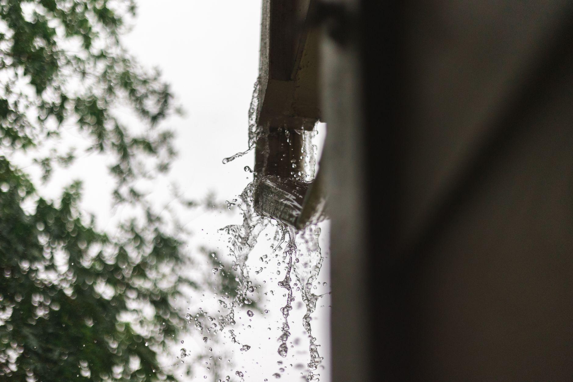 Rainwater overflowing a gutter — the kind of standing water that breeds mosquitoes