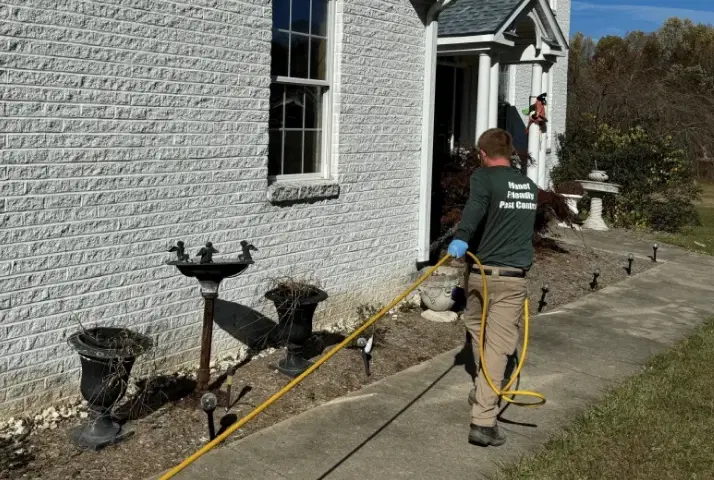 A technician inspecting the exterior of a home